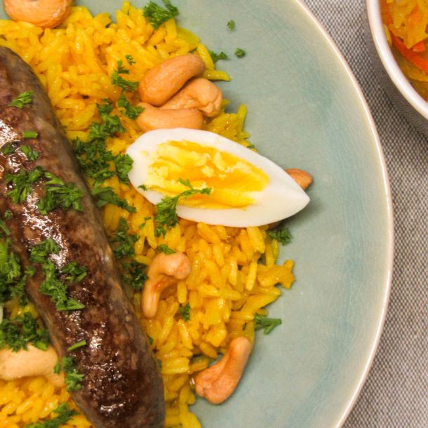 Gebakken saucijsjes met rijst, cashewnoten en een kakelvers eitje