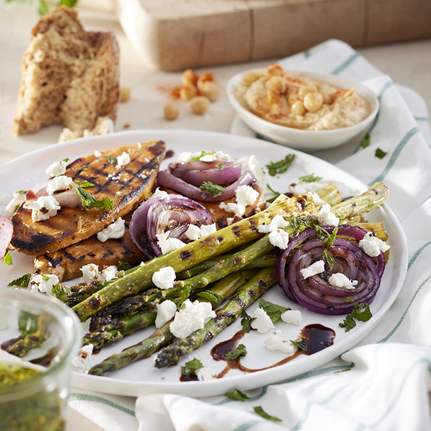 Geroosterde groene asperges met rode uien en zoete aardappel, geitenkaas, muntolie & humus