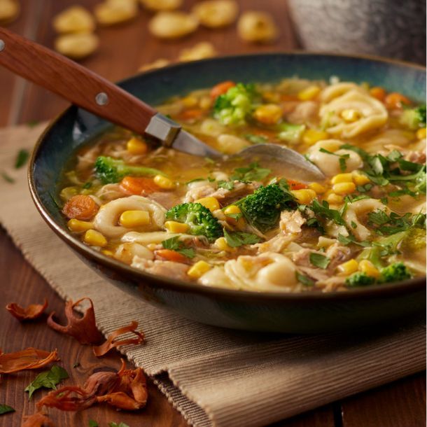 Maaltijd-kippensoep met broccoli, maïs, wortel & tortellini