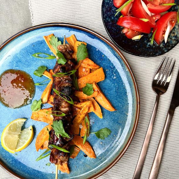 Gemarineerde scharrelhoen met zoete aardappelfriet uit de oven en een tomatensalade