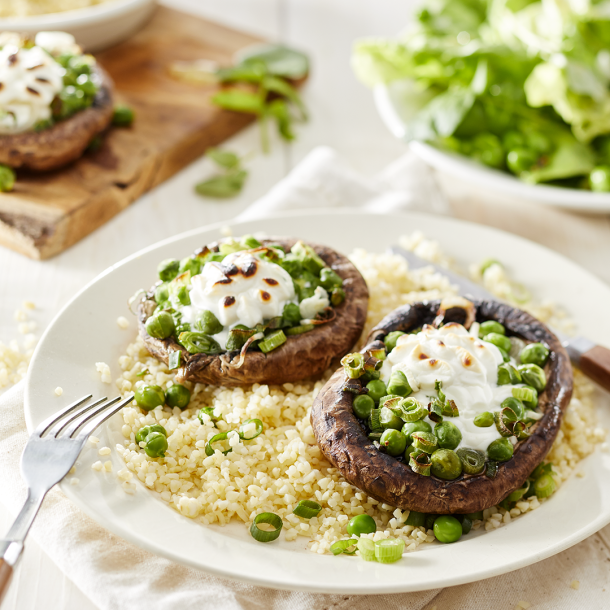 Gevulde portobello ’s met lente-ui, verse doperwtjes, geitenkaas, bulgur & waterkers-botersalade