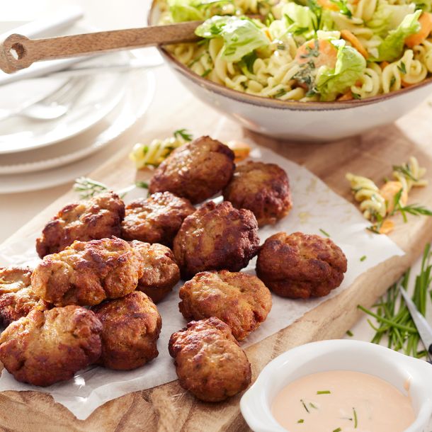 Zelfgemaakte kipnuggets met wortel-macaronisalade met wortelgroen & yoghurt-tomatendip